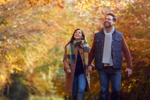 Places to See Fall Foliage in Mid-Michigan this year near Bay City, photo of a couple walking in the woods