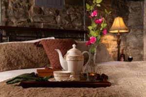 Welcome 34 A tray with cup, porcelain coffee pot, and vase of flowers sits on the bed in the Keep Room of the Historic Webster House, the best Bed and Breakfast in Michigan.