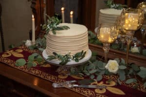 Wedding cake surrounded by candles and greenery at our romantic B&B, one of the best historic Michigan wedding venues.
